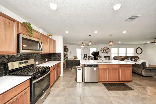 a kitchen with stainless steel appliances granite countertop a sink and stove top oven