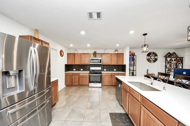 a large kitchen with kitchen island a sink stainless steel appliances and cabinets