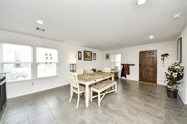 a dining room with furniture and a large window