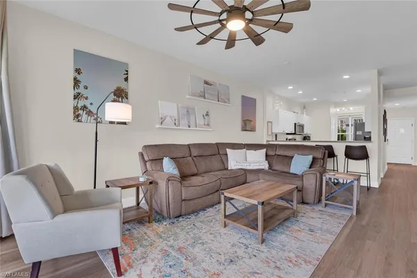 a living room with furniture kitchen view and a chandelier