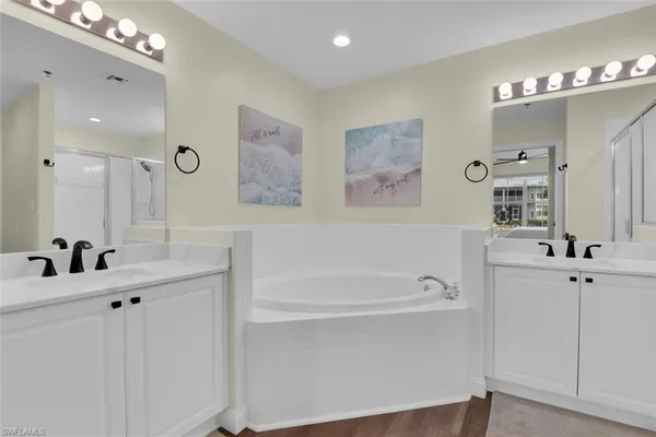 a bathroom with a tub a sink and mirror