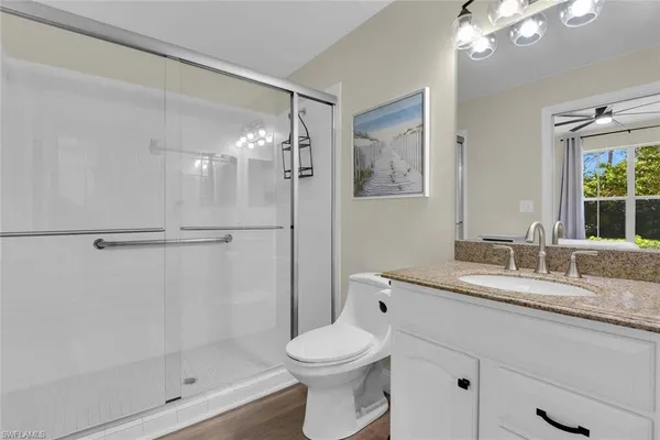 a bathroom with a granite countertop sink toilet and shower