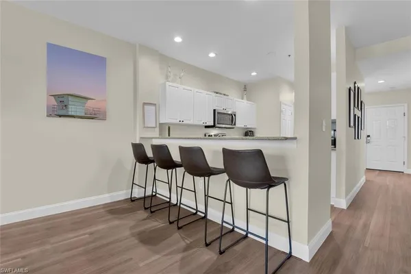a kitchen with stainless steel appliances a dining table chairs and wooden floor