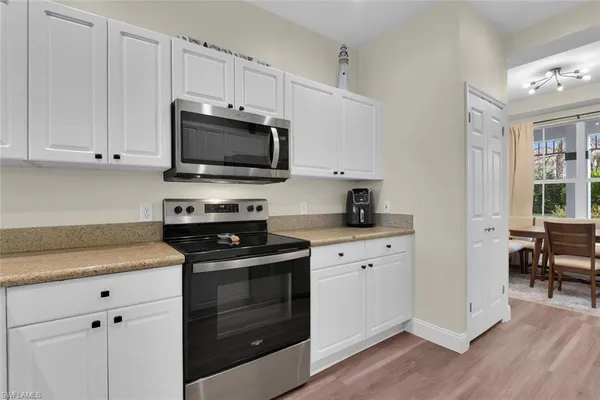 a kitchen with cabinets appliances and a window