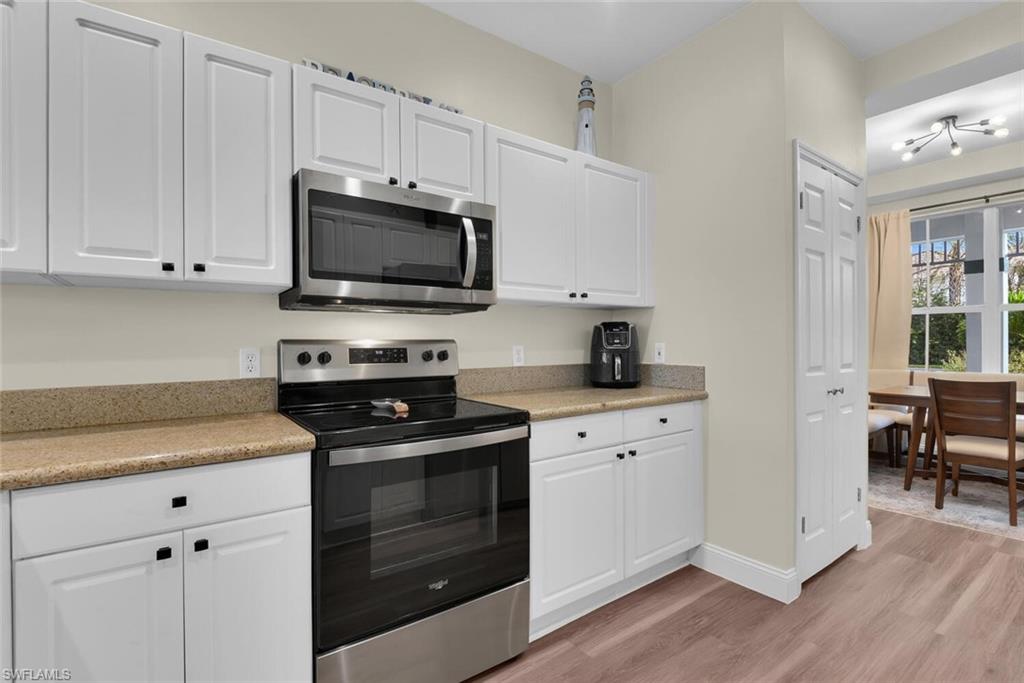 7880 Mahogany Run Lane, Unit 1614 Naples, FL 34113 - Photo 6 of 38 a kitchen with cabinets appliances and a window