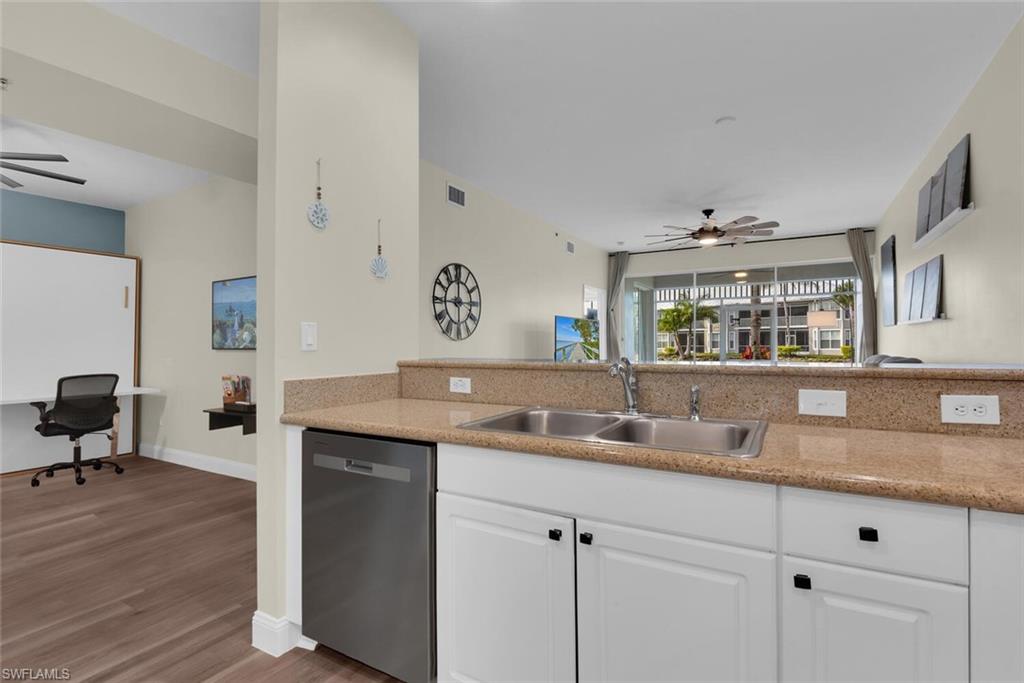 7880 Mahogany Run Lane, Unit 1614 Naples, FL 34113 - Photo 7 of 38 a kitchen with granite countertop kitchen island a sink and a stove