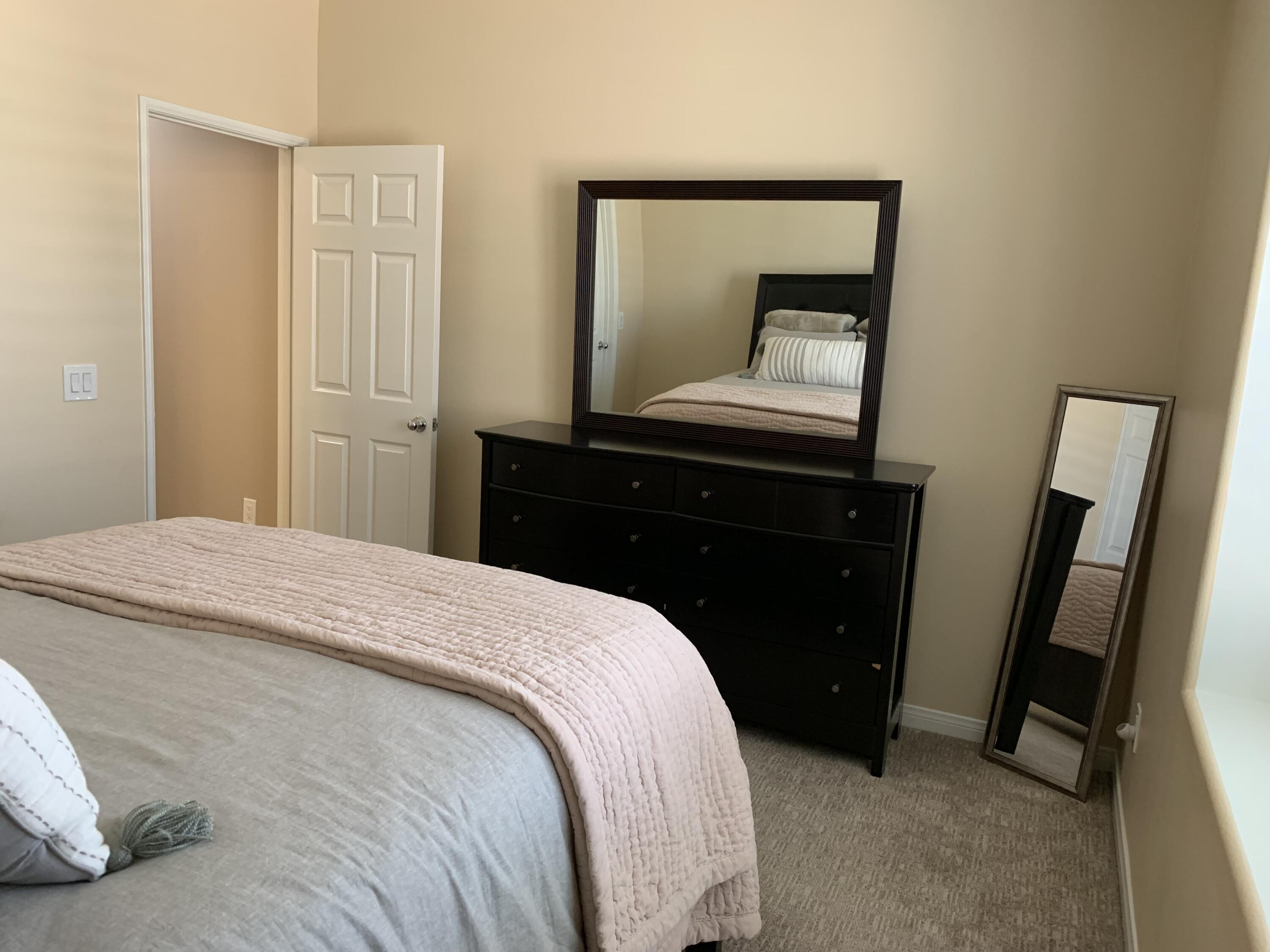 82515 Grass Flat Lane Indio, CA 92203 - Photo 18 of 44 a bedroom with a bed and a mirror on dresser