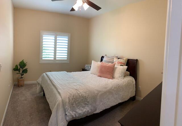 82515 Grass Flat Lane Indio, CA 92203 - Photo 22 of 44 a bedroom with a bed and a chandelier