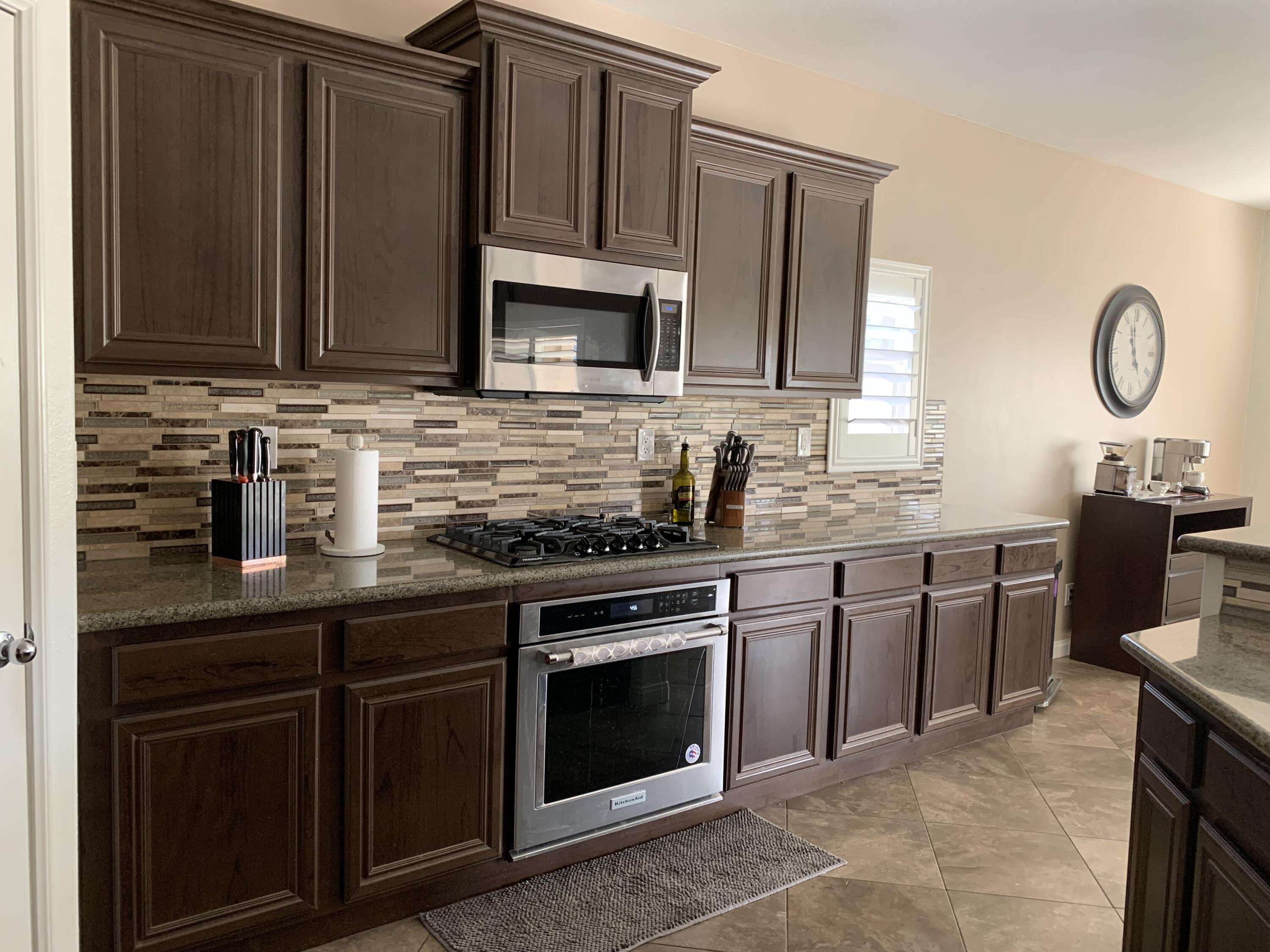 82515 Grass Flat Lane Indio, CA 92203 - Photo 5 of 44 a kitchen with stainless steel appliances granite countertop a sink stove and microwave