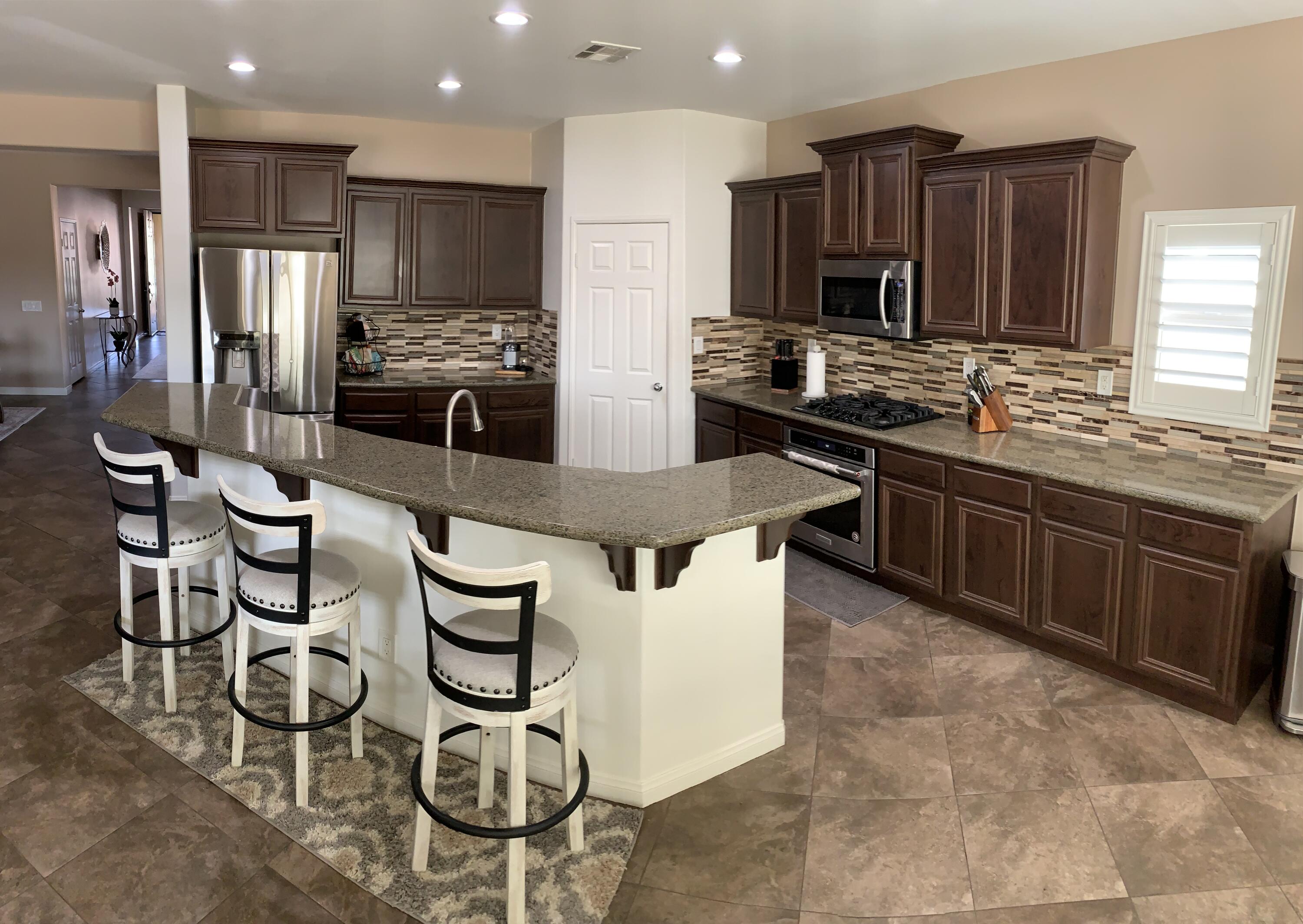 82515 Grass Flat Lane Indio, CA 92203 - Photo 7 of 44 a kitchen with stainless steel appliances granite countertop a stove refrigerator and cabinets