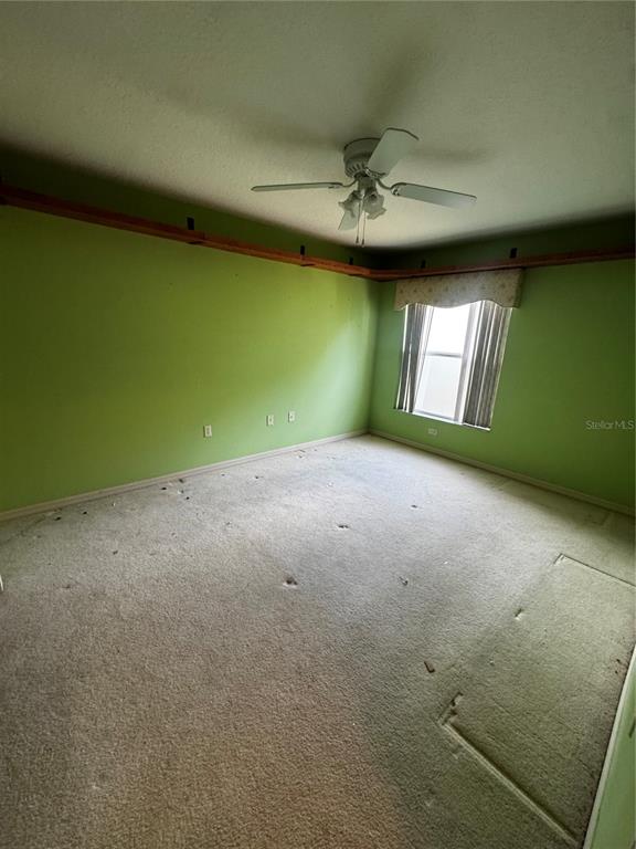 15296 Southwest 15th Terrace Road Ocala, FL 34473 - Photo 11 of 15 an empty room with a window and ceiling fan