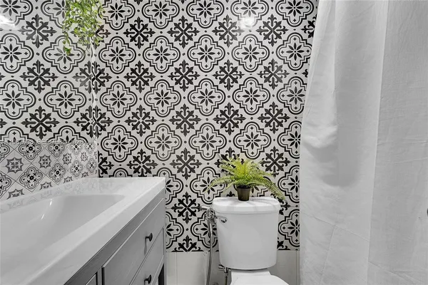 a bathroom with a sink a toilet and a mirror