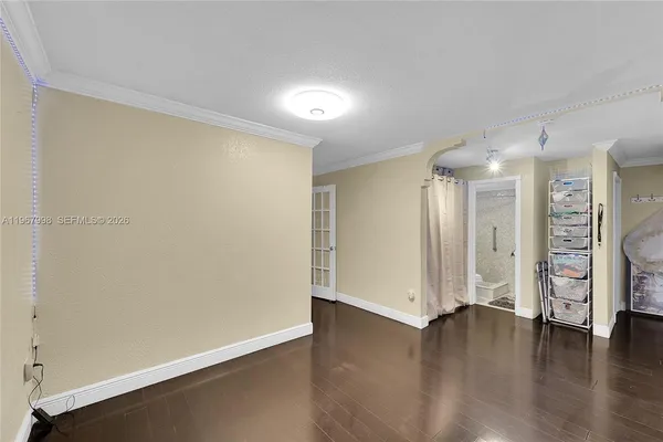 a view of an empty room with a fireplace and wooden floor