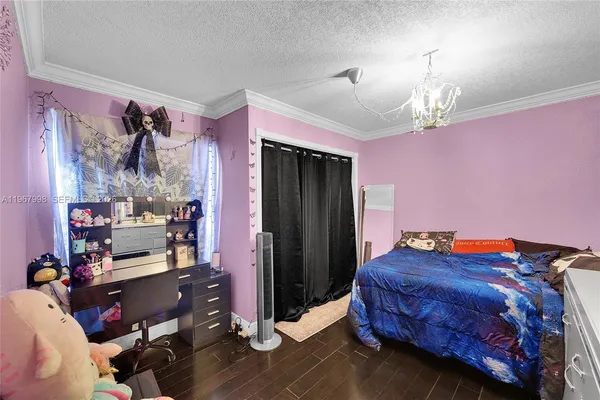 a bedroom with bed and a chandelier