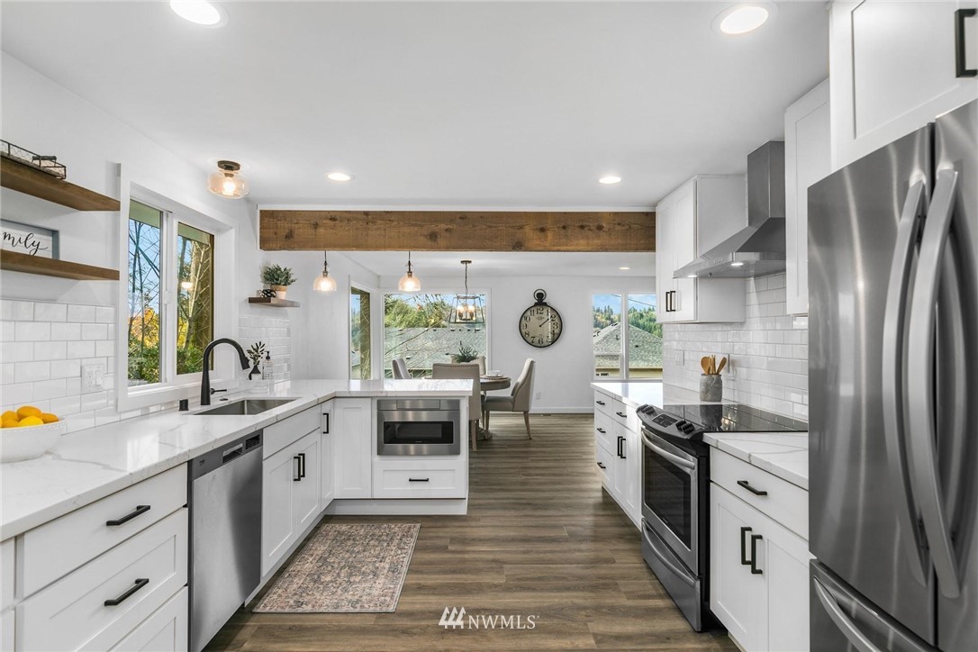 24207 39th Avenue Southeast Bothell, WA 98021 - Photo 13 of 39 a kitchen with stainless steel appliances granite countertop a sink stove and refrigerator