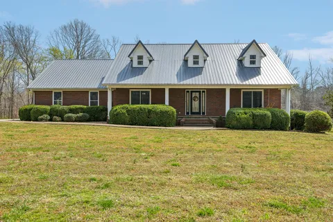 a front view of house with yard and trees around