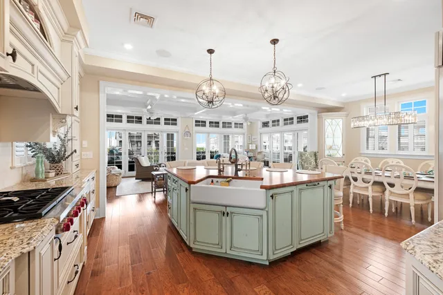 a view of a dining room and livingroom with lots of furniture wooden floor a chandelier