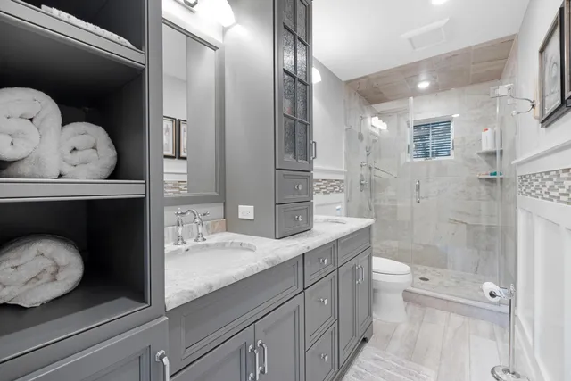 a bathroom with a granite countertop toilet sink and mirror