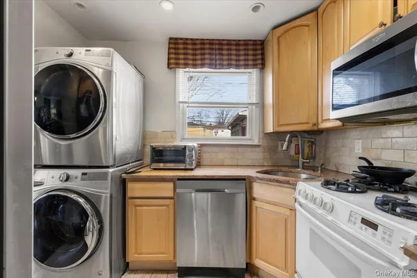 a kitchen with kitchen island a stove a sink and a microwave
