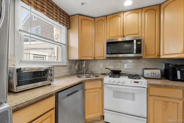 a kitchen with stainless steel appliances granite countertop white cabinets stove a sink and dishwasher