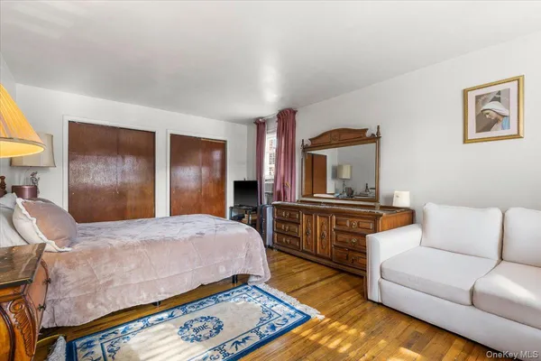 a bedroom with a bed and a dresser with rug