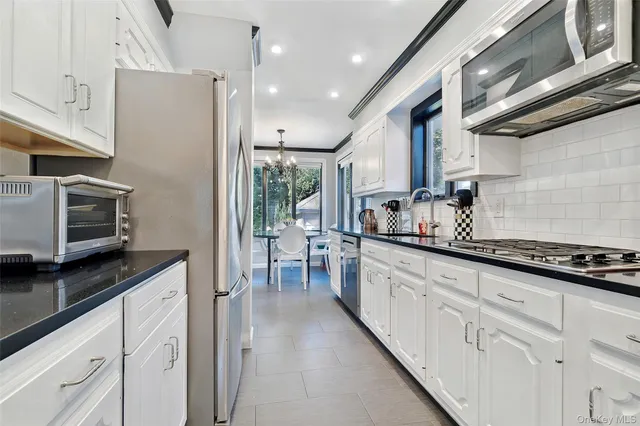 a kitchen with granite countertop cabinets a sink a window and stainless steel appliances