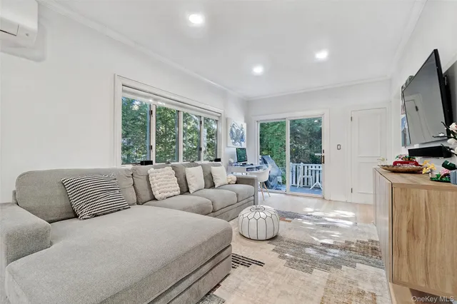 a living room with furniture a flat screen tv and a large window