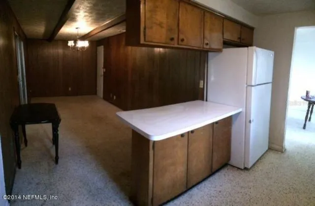 a kitchen with refrigerator and cabinets