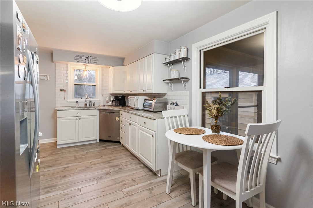 3701 Shields Road Canfield, OH 44406 - Photo 7 of 15 Kitchen featuring stainless steel appliances, white cabinetry, light wood-style flooring, and light stone counters
