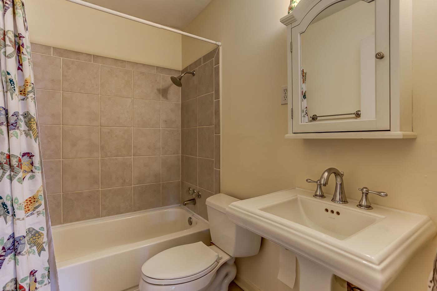 801 Moss Road Memphis, TN 38117 - Photo 17 of 28 Tile floor, pedestal vanity, custom tile shower walls with steel tub and linen closet.