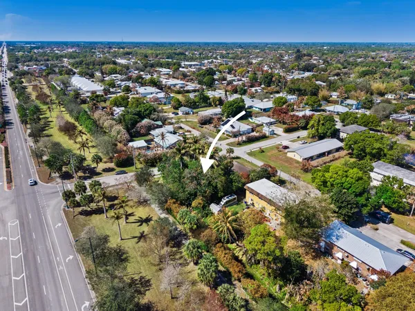 an aerial view of residential houses with outdoor space and trees