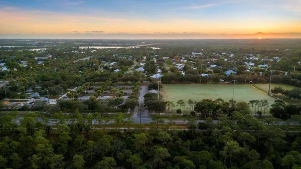 an aerial view of residential houses with outdoor space and ocean view