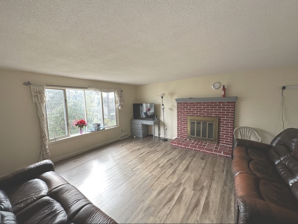 24 Emerson Street Springfield, MA 01118 - Photo 4 of 19 wooden floor fireplace and windows in an empty room