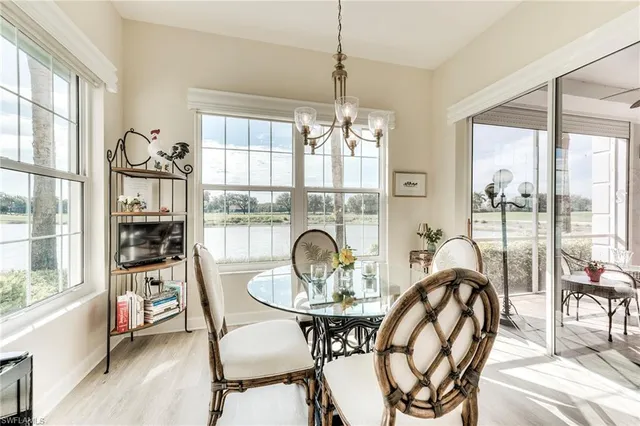 a dining room with furniture water view and a floor to ceiling window