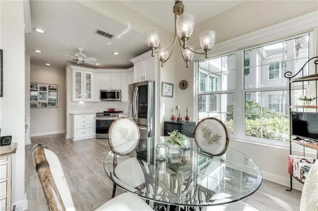 a dining room with wooden floor a chandelier a wooden table and chairs