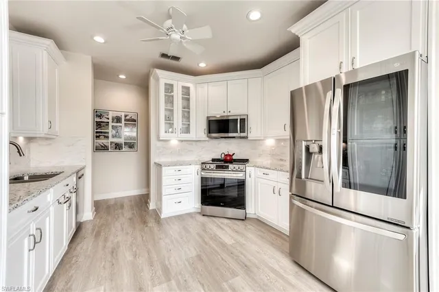 a kitchen with stainless steel appliances granite countertop a refrigerator stove and sink