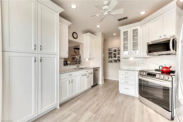 a kitchen with stainless steel appliances white cabinets and stove
