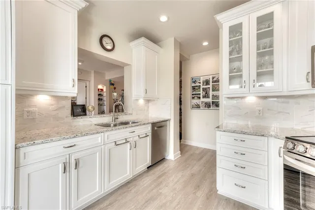 a kitchen with granite countertop white cabinets and white appliances