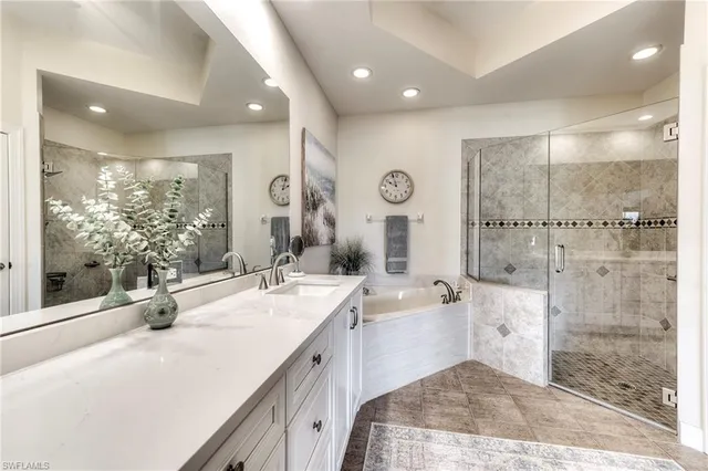 a bathroom with a tub sink mirror and shower