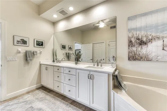 a spacious bathroom with a tub sink and mirror