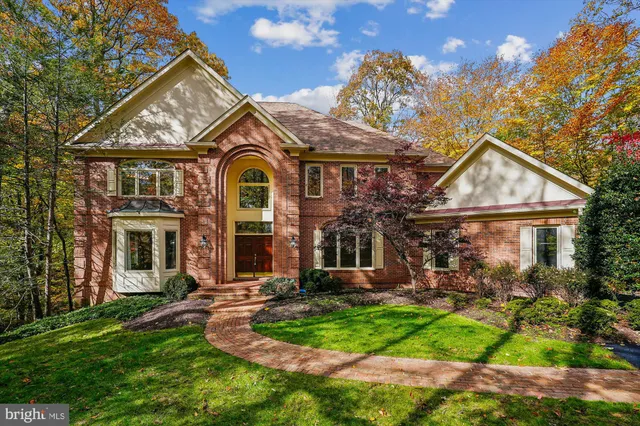 a view of a house with brick walls and a yard with plants