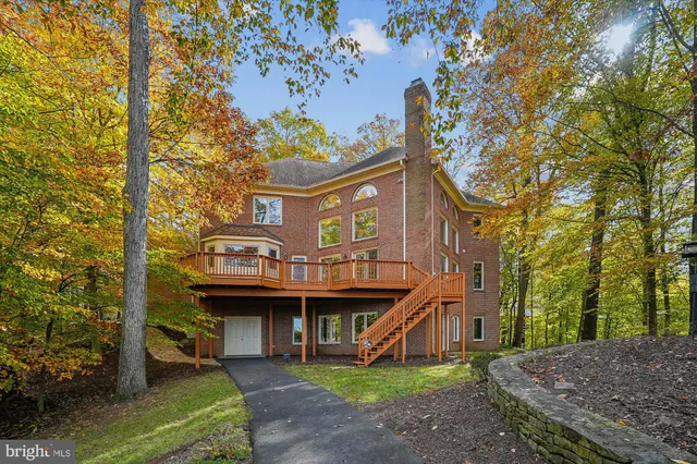 a view of an empty room with wooden floor and windows