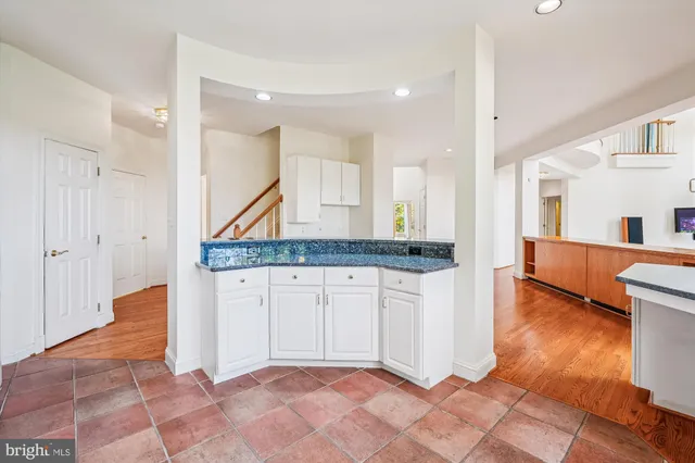 a view of a white house with a dining table and chairs