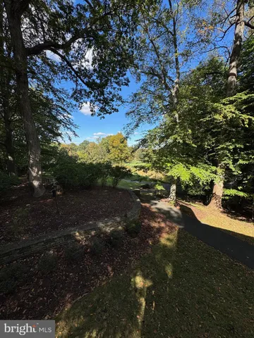 a view of a big house with a big yard and large trees