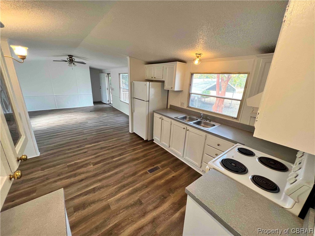 1295 Kates Neck Road Locust Hill, VA 23092 - Photo 16 of 24 Kitchen with dark hardwood / wood-style floors, ceiling fan, white refrigerator, and white cabinets