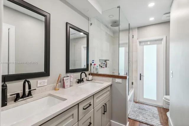 a bathroom with double vanity sinks and a mirror