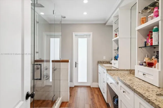 a large kitchen with a lot of counter space and wooden floor