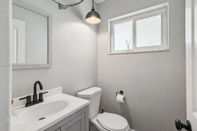 a bathroom with a toilet a sink and mirror
