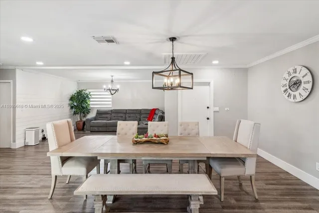 a view of a dining room with furniture wooden floor and chandelier