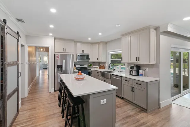 a kitchen with refrigerator a sink and wooden cabinets